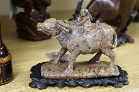 Three Chinese figural wood carvings and a soapstone carving of a child riding a water buffalo,